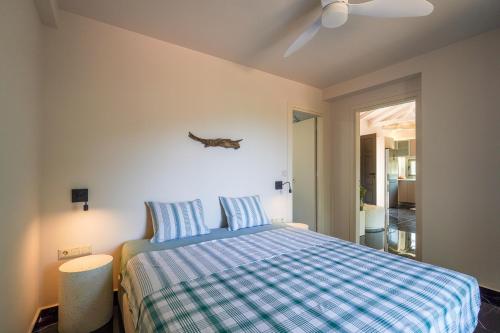 a bedroom with a bed with a blue and white blanket at Boutique House Thalassori in Agios Nikolaos