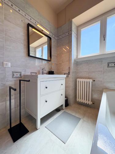 a bathroom with a white sink and a mirror at Borgo Design Apartment by the sea in Civitavecchia