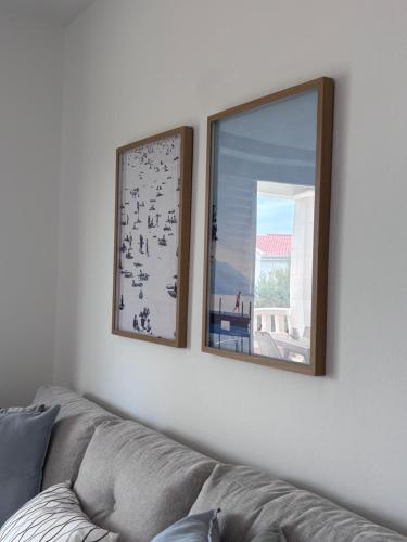 two mirrors on a white wall next to a couch at Villa Lulu in Orebić