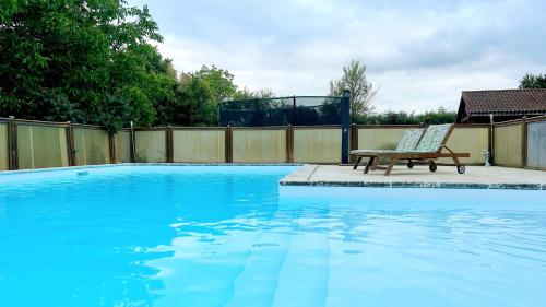 un banco sentado junto a una piscina en La Closerie des Arts, en Gabillou