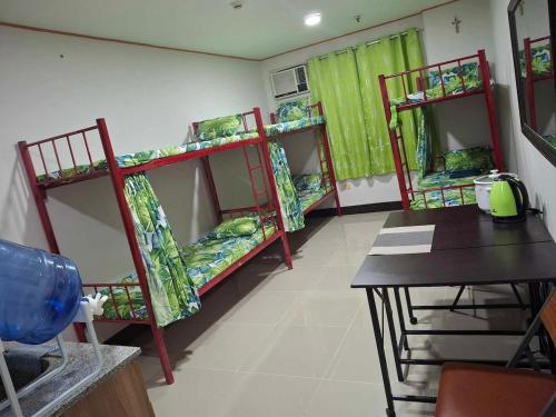 a room with three bunk beds and a table at Room for rent - SMR in Cebu City