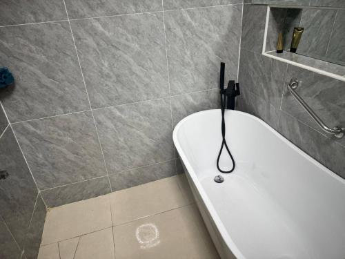 a bathroom with a bathtub with a hanger on it at Serene Oasis in Lagos - Private Pool Relaxing Ambiance in Lagos