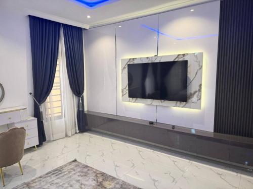 a living room with a television on a wall at Serene Oasis in Lagos - Private Pool Relaxing Ambiance in Lagos