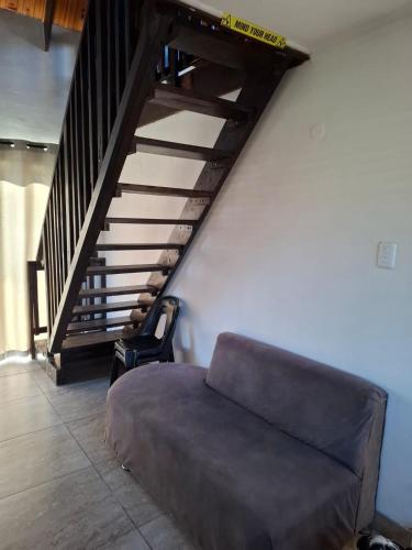 a couch in a living room with a staircase at The View in George
