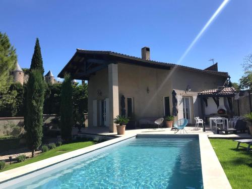 a villa with a swimming pool in front of a house at Panorama by maison bacou in Carcassonne