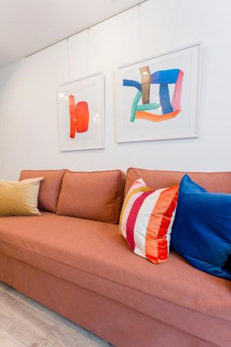 a brown couch with colorful pillows in a room at Jasmine Style Akasaka in Tokyo