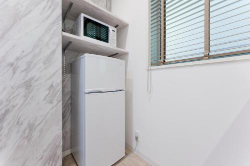 a white refrigerator in a kitchen with a window at Jasmine Style Akasaka in Tokyo
