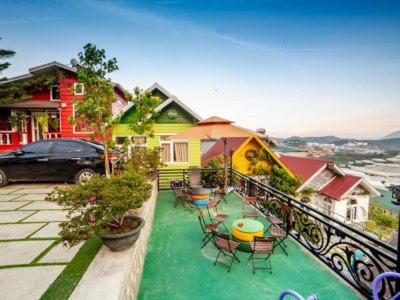 a house with chairs and tables on a balcony at Sweet Home Dalat - Homestay in Da Lat