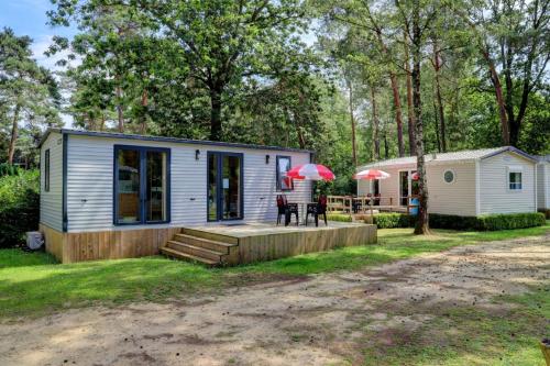 a tiny house with a porch and a patio at Safari Tenten met Sanitair 4 personen in Kasterlee