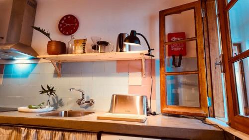 a kitchen counter with a sink and a window at Casa do Lambril in Tinalhas
