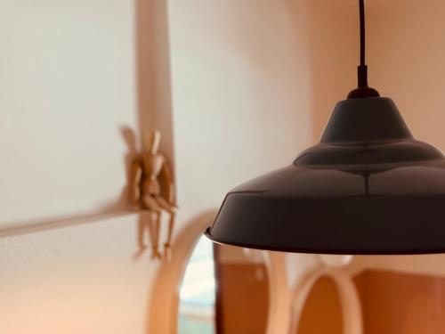 a black pendant light hanging next to a chair at Casa do Lambril in Tinalhas