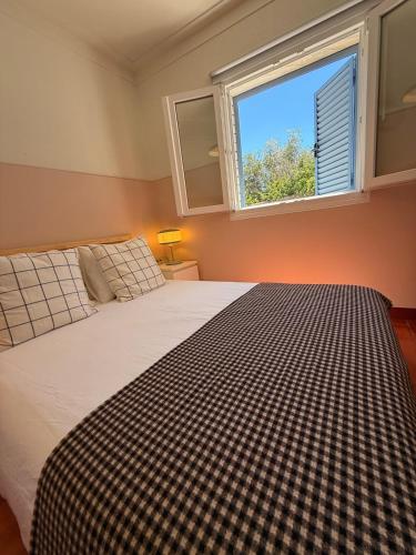 a bedroom with a large bed with a window at Casa do Lambril in Tinalhas