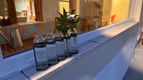 a row of glass bottles sitting on a window sill at Casa do Lambril in Tinalhas