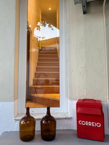 two bottles sitting on a ledge in front of a window at Casa do Lambril in Tinalhas