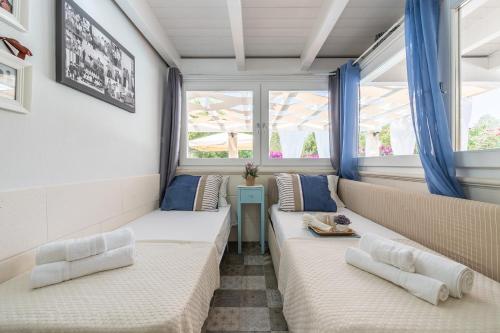 萨罗克Nido sul Mare的客厅设有2张沙发和2扇窗户