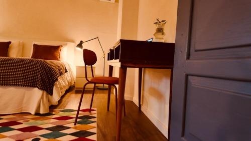 a bedroom with a bed and a desk with a chair at Casa do Lambril in Tinalhas