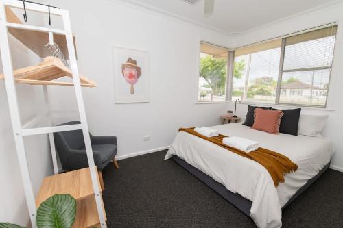 a bedroom with a bed and a book shelf at Haven on Hill - Modern & Charming, Touch of Pink in Orange