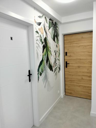 a room with a door and a wall with a flower mural at Apartamenty Częstochowa in Częstochowa
