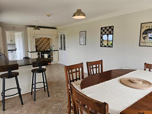 a kitchen and dining room with a table and chairs at Fiáin Retreat in Miltown Malbay