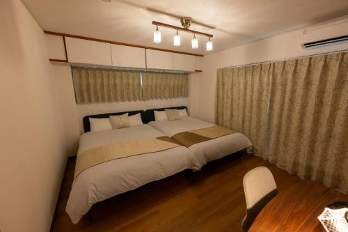 una camera da letto con un letto grande e una sedia di Vacation Rental -Nagumo301- a Tokyo