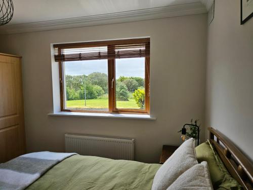 a bedroom with a bed and a window at Fiáin Retreat in Miltown Malbay