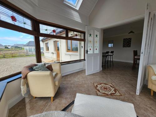 a living room with a couch and a large window at Fiáin Retreat in Miltown Malbay