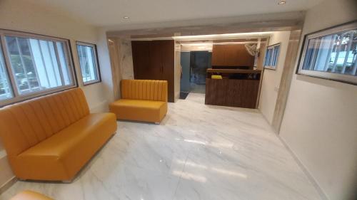 an empty room with two chairs and a couch at Hotel Vrindavan Nashik in Nashik