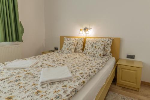 a bedroom with a large bed with two pillows at Pensiunea Patakparti 4 in Praid