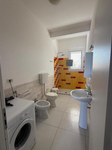 a bathroom with two toilets and a washing machine at Torre Lapillo in Torre Lapillo