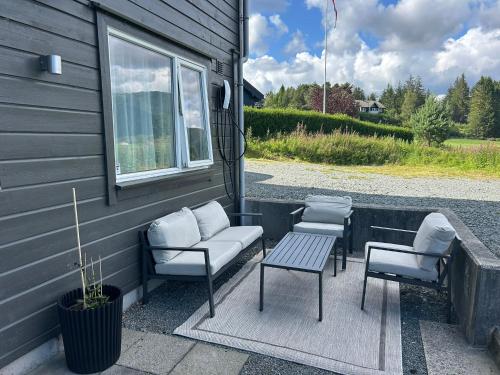 a patio with a couch and chairs and a table at Apartment Suite in Os in Osøyro