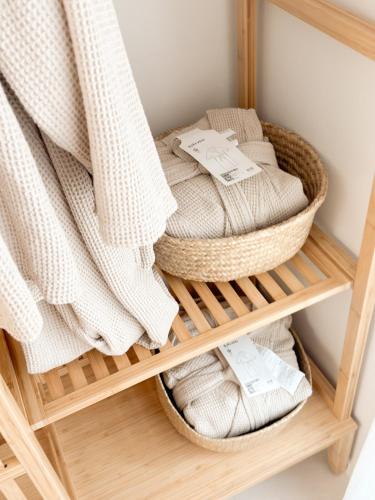 a basket of towels on a shelf in a bathroom at 3-Min Walk from Achasan Station, 2-Bedroom Bali Mood Stay with Hinoki Aroma in Seoul