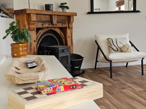a living room with a table and a fireplace at Fiáin Retreat in Miltown Malbay