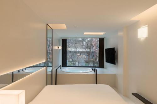 a bedroom with a bed and a window at SFEEL设计师酒店Designer Hotel成都太古里滨江路店 in Chengdu