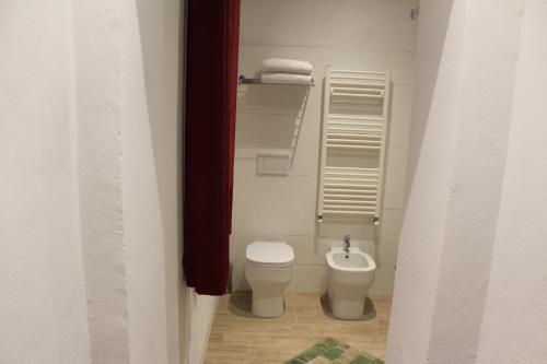 a small bathroom with a toilet and a sink at Villa Lilia by Let in Siena
