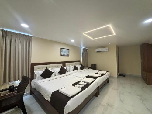 a bedroom with a large bed and a desk at Hotel OP Palace in Colva
