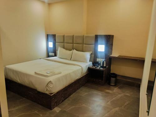 a bedroom with a large bed with two lights on it at Hotel Richie Residency in Mumbai