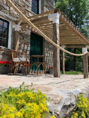 a patio with a table and a chair in front of a building at Cabin Valle Cervo 