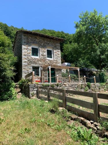an old stone house behind a wooden fence at Cabin Valle Cervo 