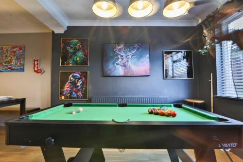a pool table in a room with pictures on the wall at Spacious 3 Bed Home with Pool Table in Cardiff
