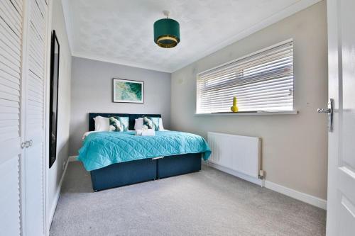a bedroom with a blue bed and a window at Spacious 3 Bed Home with Pool Table in Cardiff
