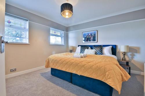 a bedroom with a large bed with a yellow bedspread at Spacious 3 Bed Home with Pool Table in Cardiff