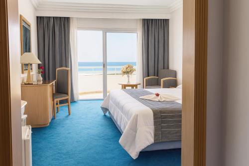 Una habitación de hotel con una cama y vista al océano. en Bizerta Resort Congres & SPA, en Bizerte
