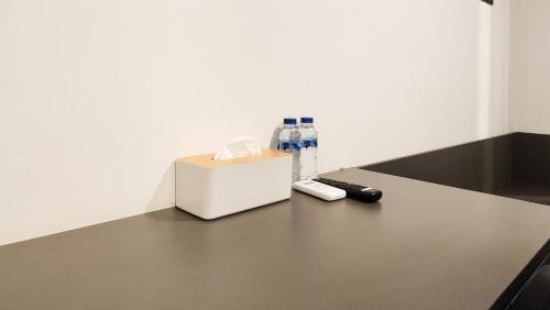 a table with a bottle of water and a remote control at Sans Vibes Hotel Damai Yogyakarta in Kejayan