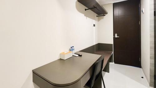 a room with a table and a black door at Sans Vibes Hotel Damai Yogyakarta in Kejayan