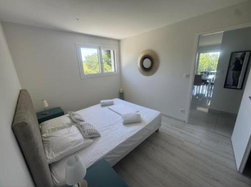 a white bedroom with a bed and a window at Le Petit Bois évasion nature entre Genève&Annecy in Copponex