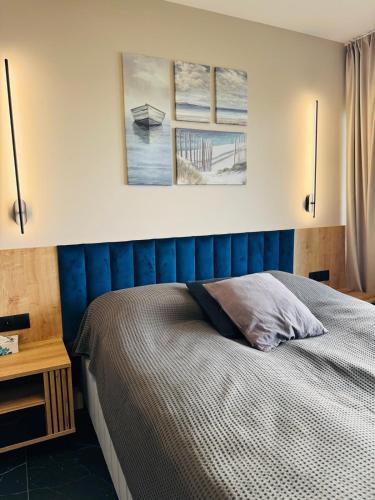 a bedroom with a bed with two pictures on the wall at Solaris Darłówko Premium Emilia Strupiechowska in Darłowo