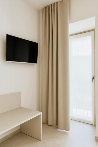 a living room with a tv and a curtain at Ca' Santina in Stoccareddo