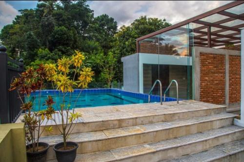 a house with a swimming pool and stairs at Hotel Malika Inn 