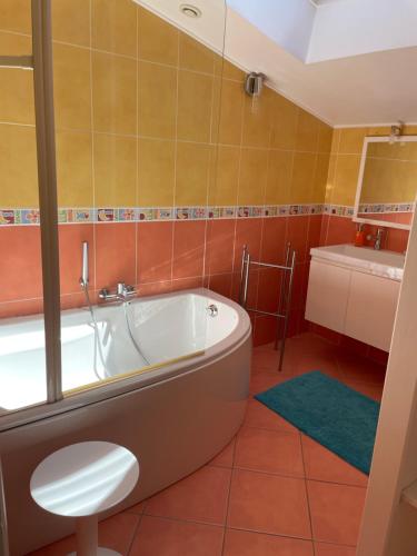 une salle de bain avec une baignoire et un lavabo dans l'établissement Charentaise contemporaine, à Anais