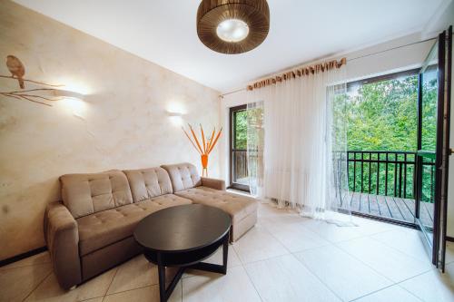 a living room with a couch and a table at Apartamentowiec Panorama Gór City Center Family&Pet-friendly in Szklarska Poręba